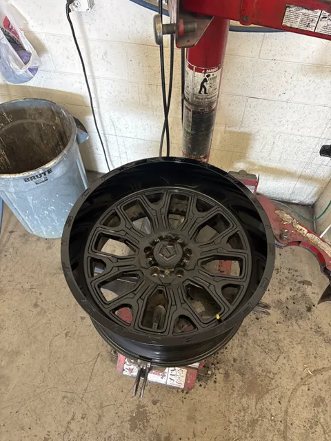 The wheel's lip smoothed and repainted, matching the factory black finish